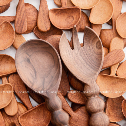 Handcrafted walnut wood salad servers with beaded handles, featuring a serving spoon and fork set on mushroom wood spoon background by 194 Craft House.