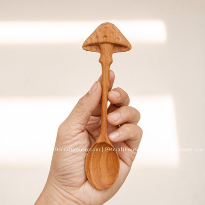 Mushroom wooden coffee spoon held in hand to show its size and handcrafted design