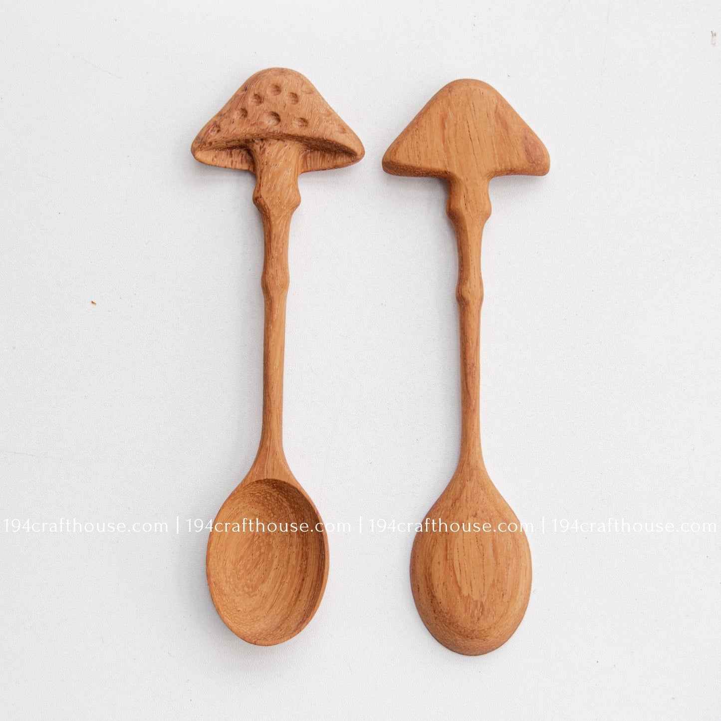 Two unique mushroom-shaped wooden spoons with different handcrafted designs