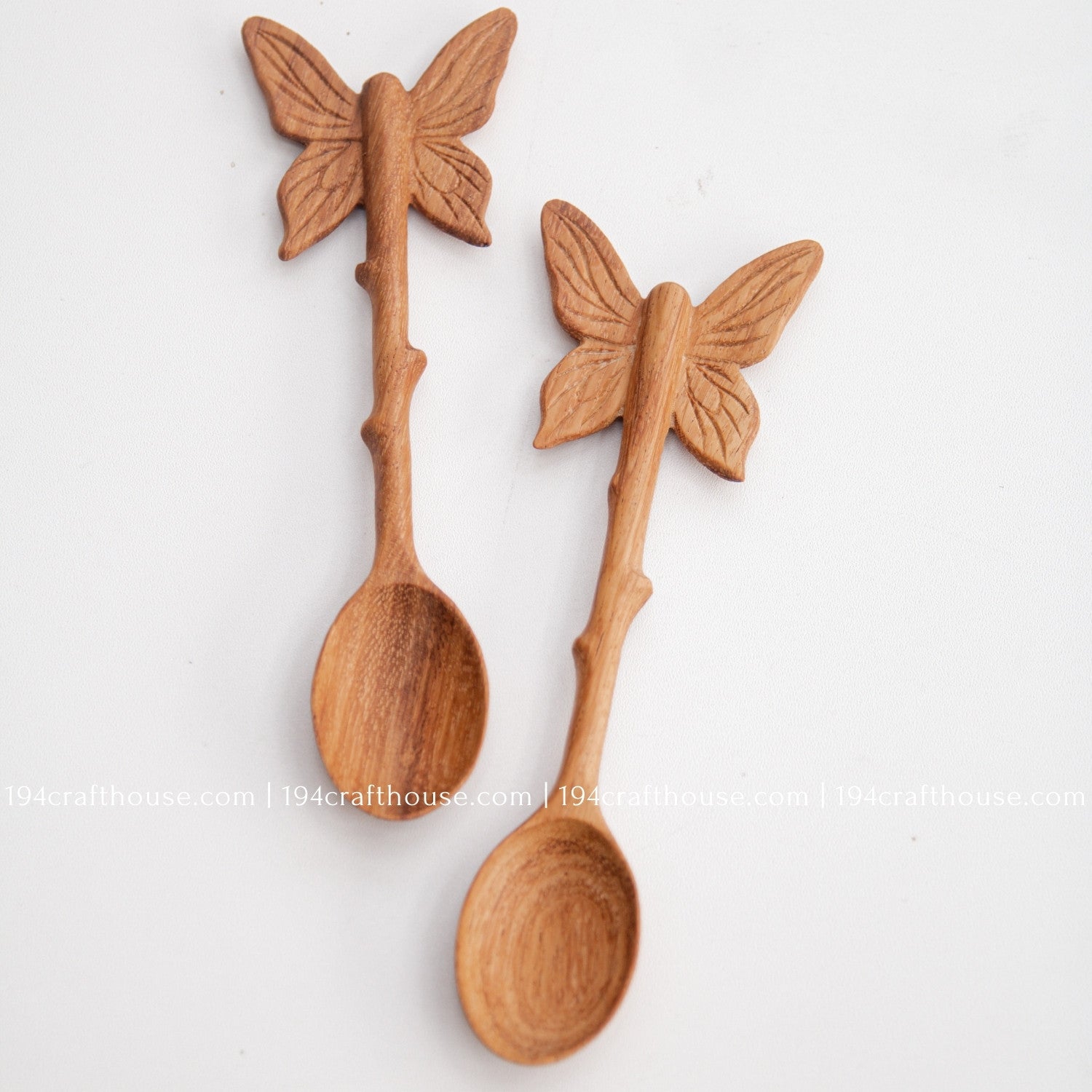 Hand-carved Butterfly wooden spoonscrafted from doussie wood, featuring a sculpted butterfly handle on a white background.