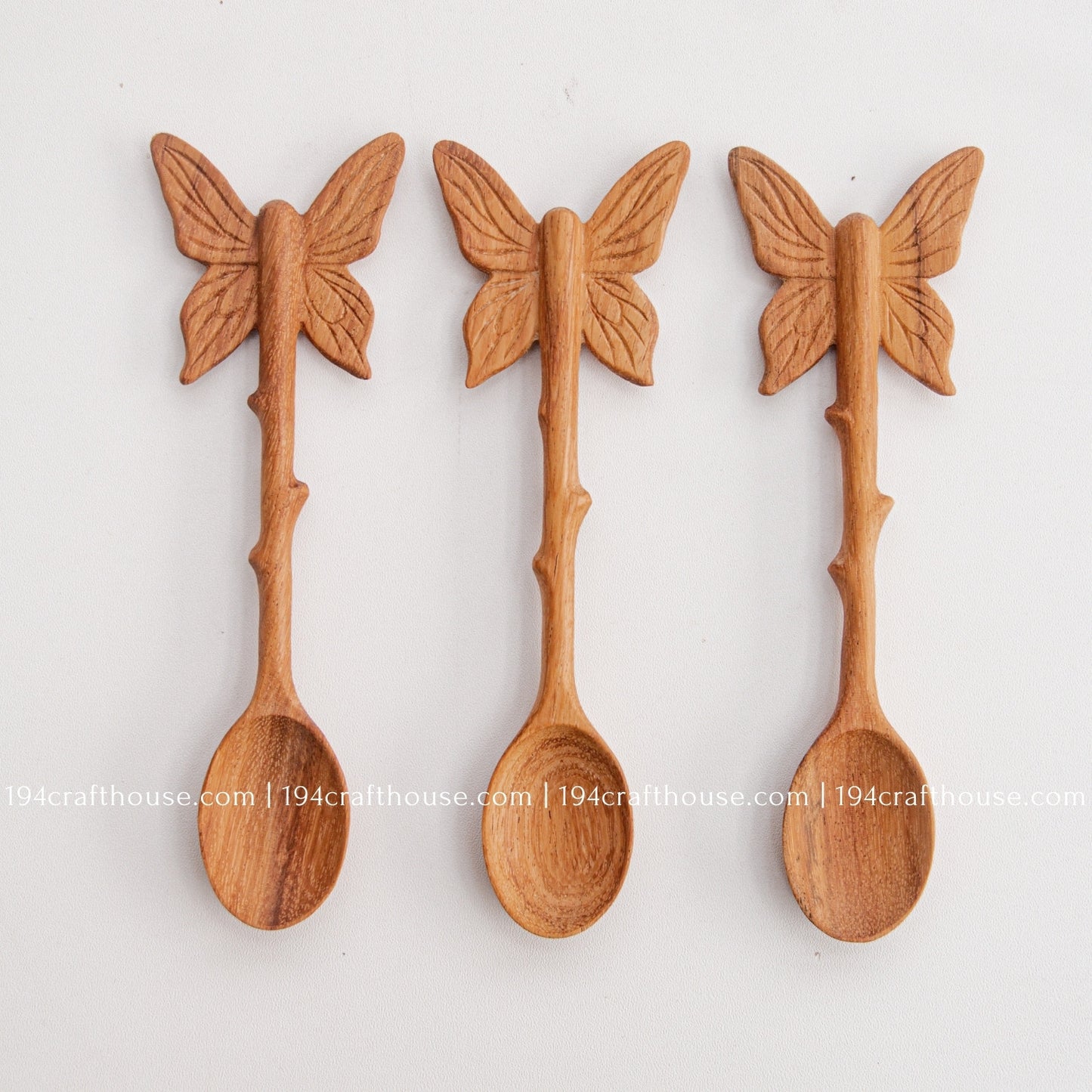 Hand-carved Butterfly wooden spoons crafted from doussie wood, featuring a sculpted butterfly handle on a white background.