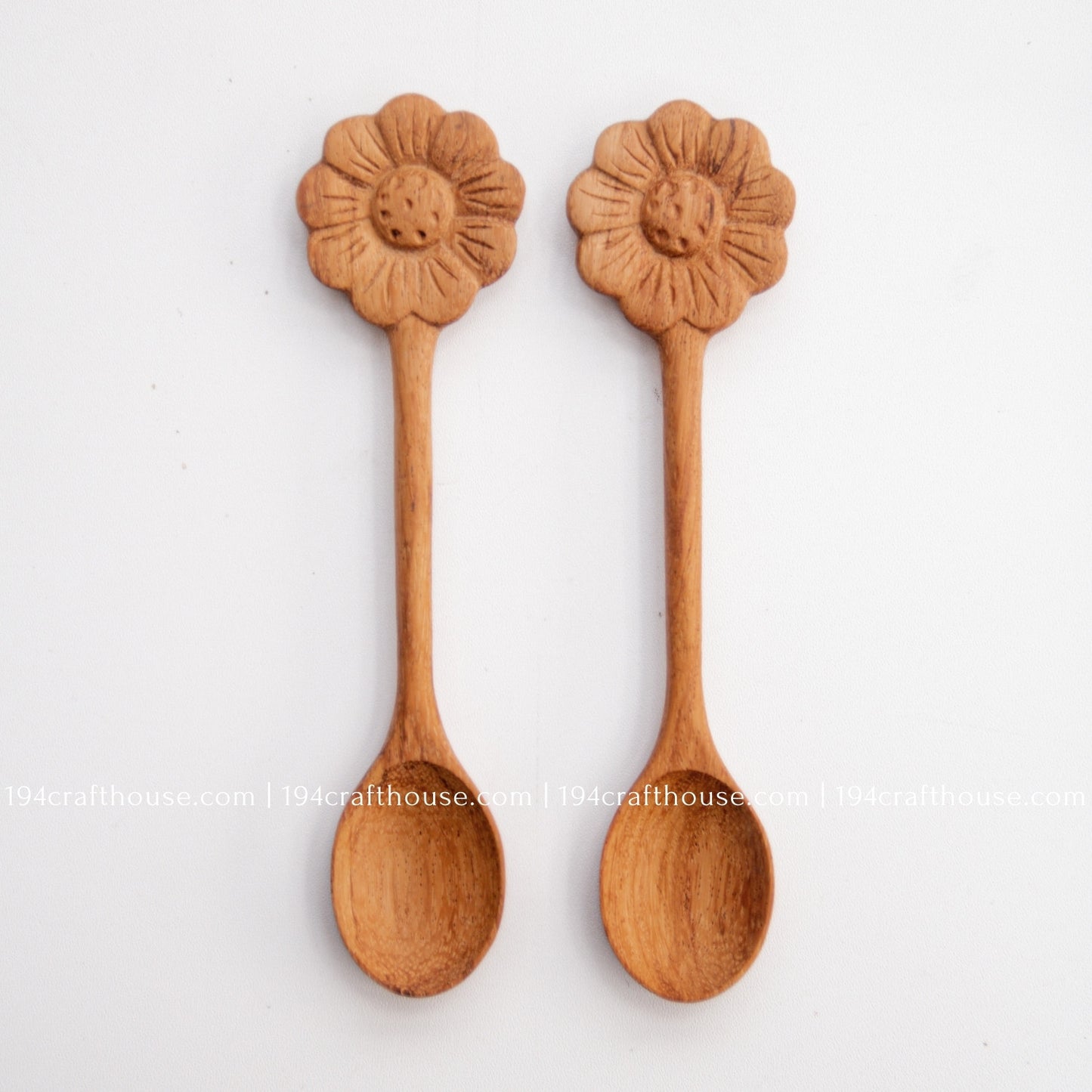 Hand-carved Flower wooden spoons crafted from doussie wood, featuring a sculpted flower handle on a white background.