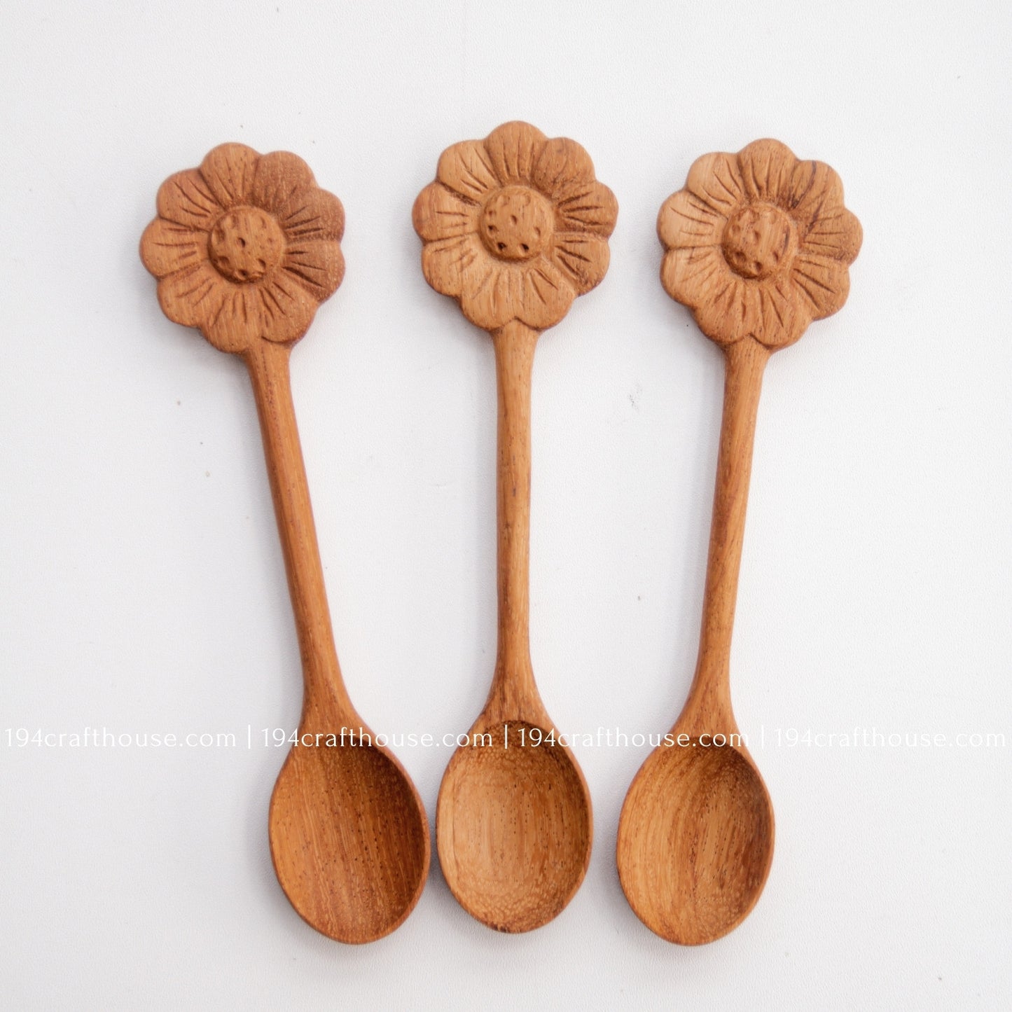 Hand-carved Flower wooden spoons crafted from doussie wood, featuring a sculpted flower handle on a white background.