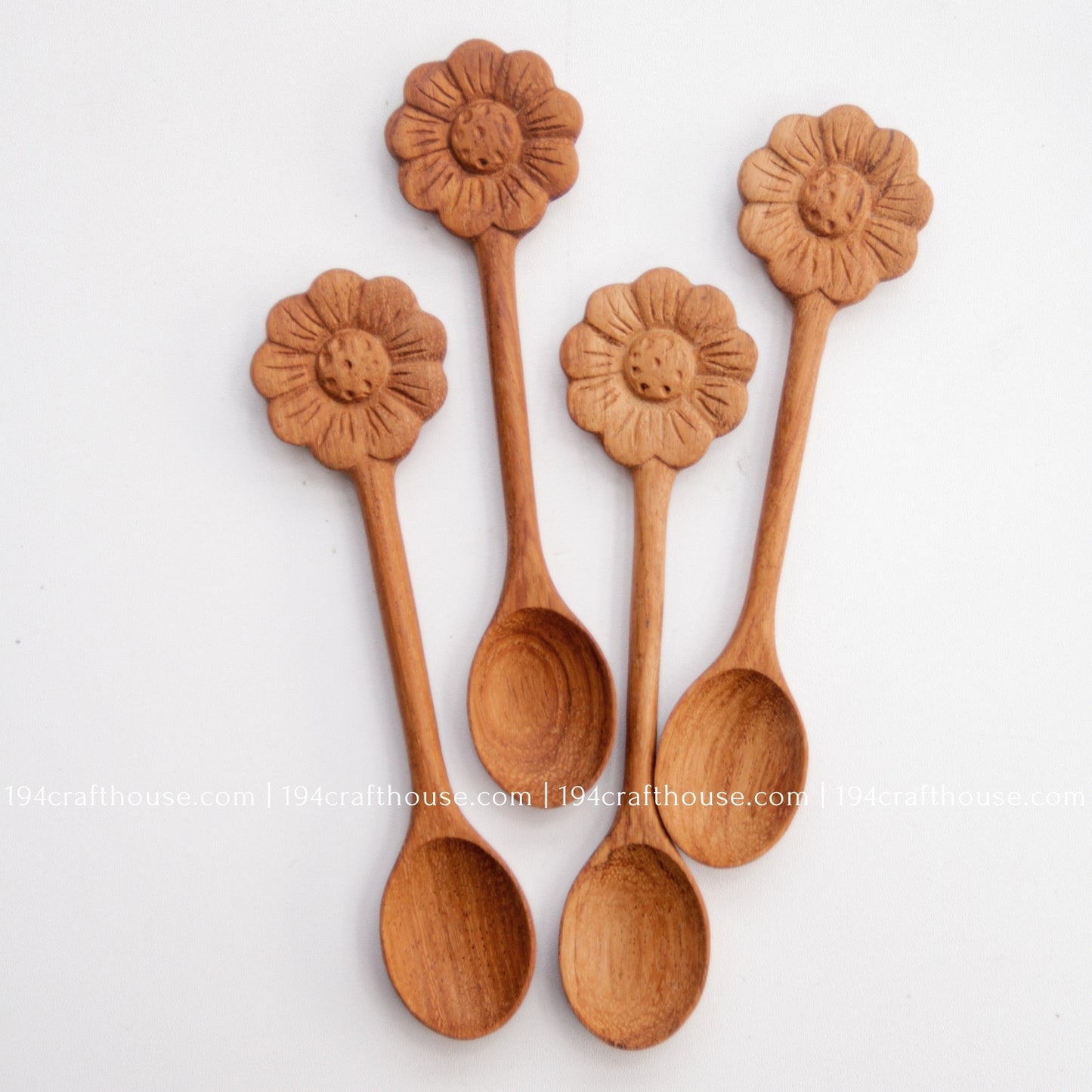Hand-carved Flower wooden spoons crafted from doussie wood, featuring a sculpted flower handle on a white background.
