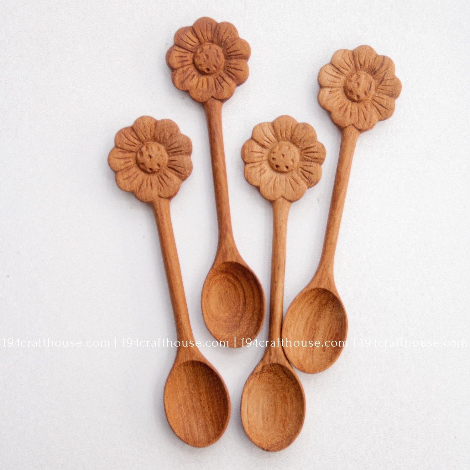 Hand-carved Flower wooden spoons crafted from doussie wood, featuring a sculpted flower handle on a white background.