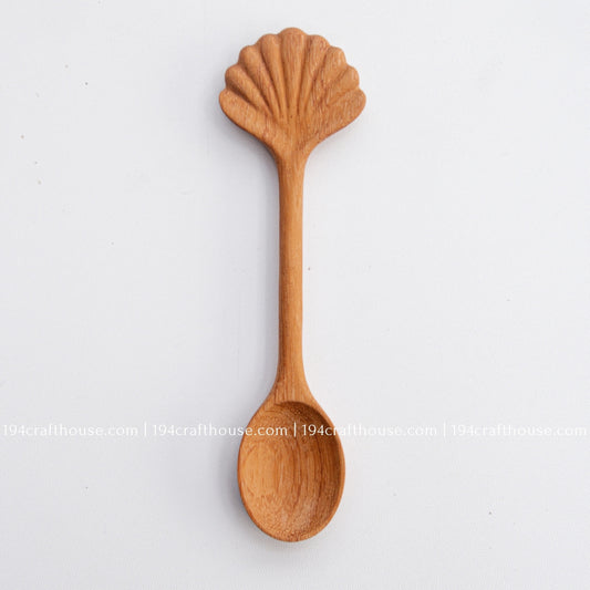 Hand-carved seashell wooden spoon crafted from doussie wood, featuring a sculpted mushroom cap handle on a white background.