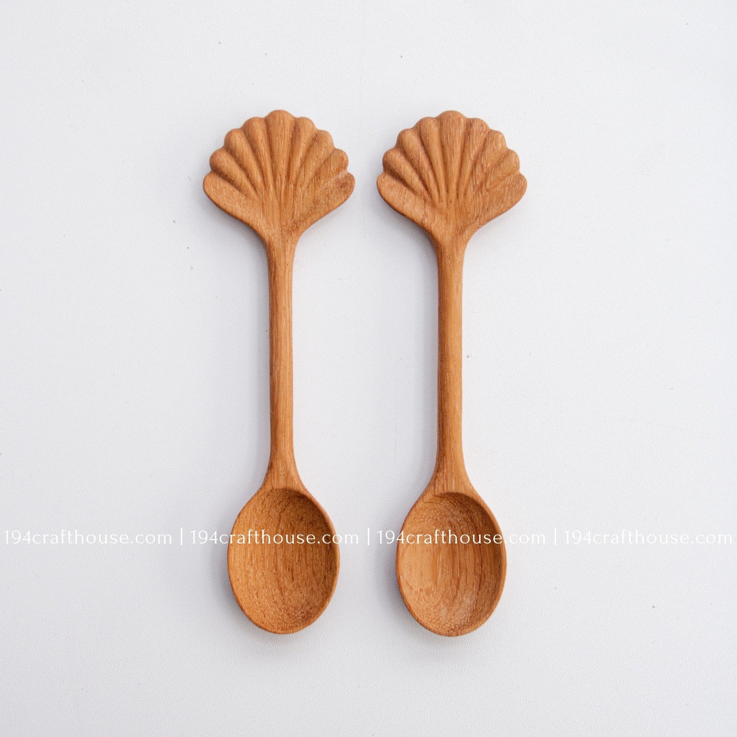 Hand-carved seashell wooden spoon crafted from doussie wood, featuring a sculpted mushroom cap handle on a white background.