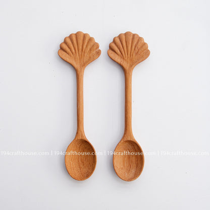 Hand-carved seashell wooden spoon crafted from doussie wood, featuring a sculpted mushroom cap handle on a white background.