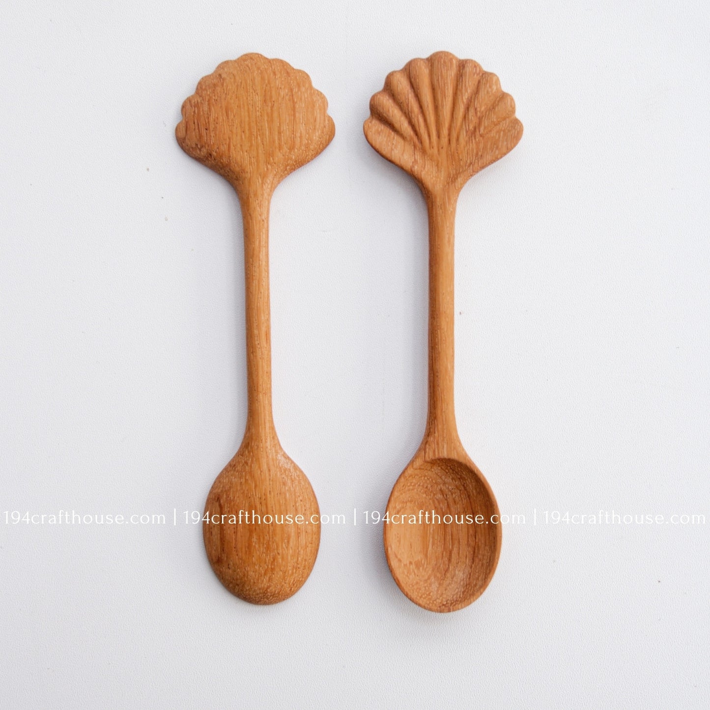 Hand-carved seashell wooden spoon crafted from doussie wood, featuring a sculpted mushroom cap handle on a white background.