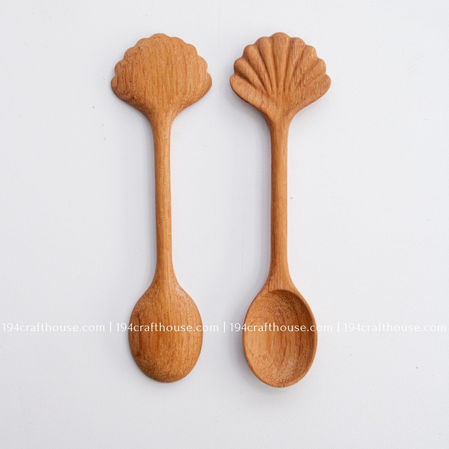 Hand-carved seashell wooden spoon crafted from doussie wood, featuring a sculpted mushroom cap handle on a white background.