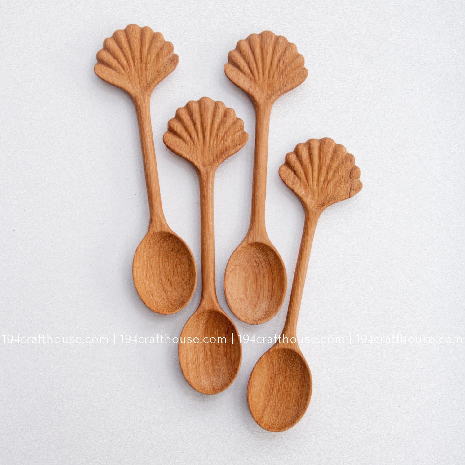 Hand-carved seashell wooden spoon crafted from doussie wood, featuring a sculpted mushroom cap handle on a white background.