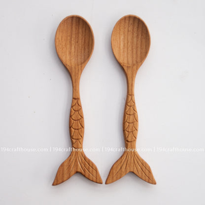 Two fish-tail handle Doussie wood spoons side by side, showing natural grain and carving variation.
