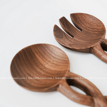 Detailed view of the wooden salad spoon and fork heads with a smooth finish and carved handles