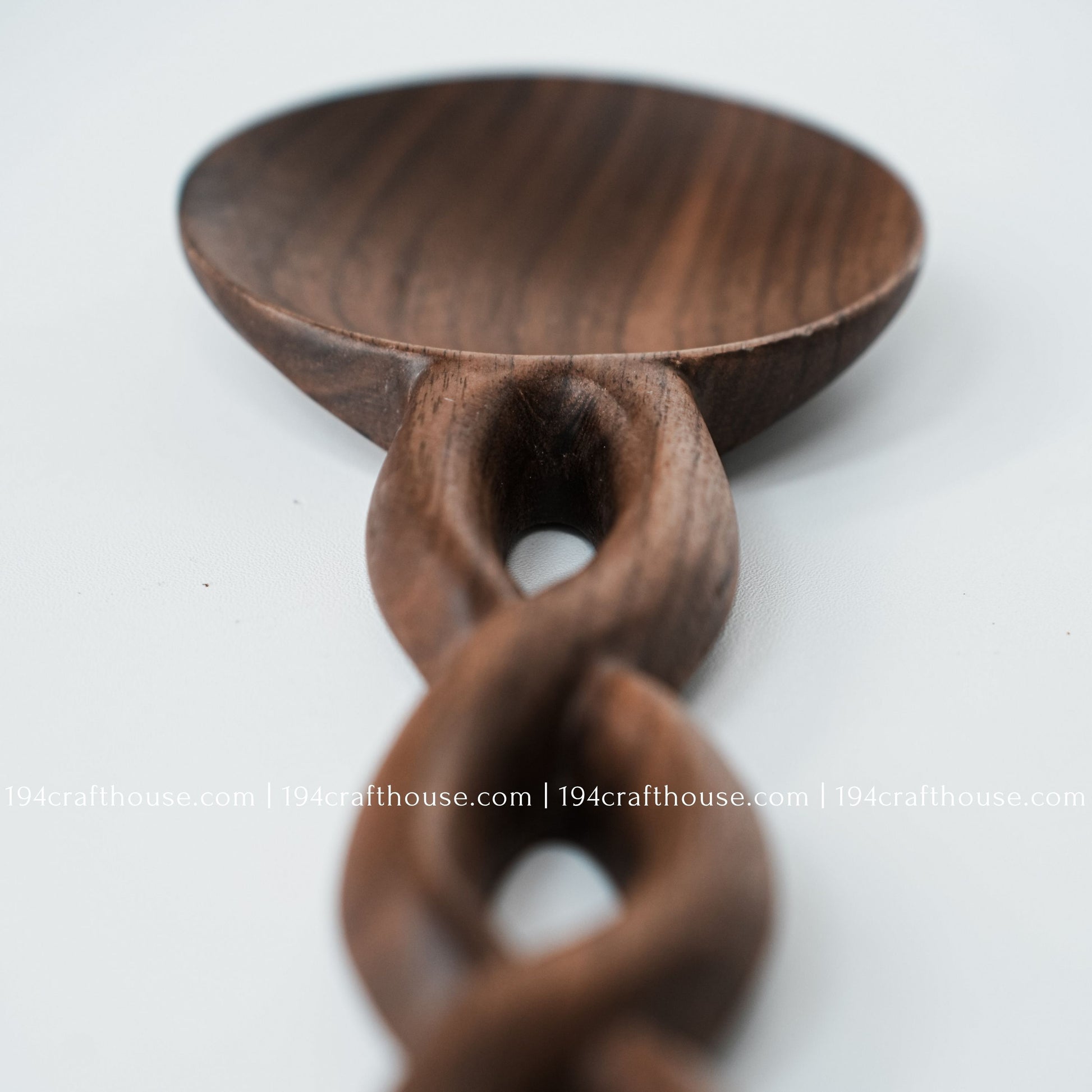 Close-up of the wooden salad fork with a carved chain-link handle and natural wood grain