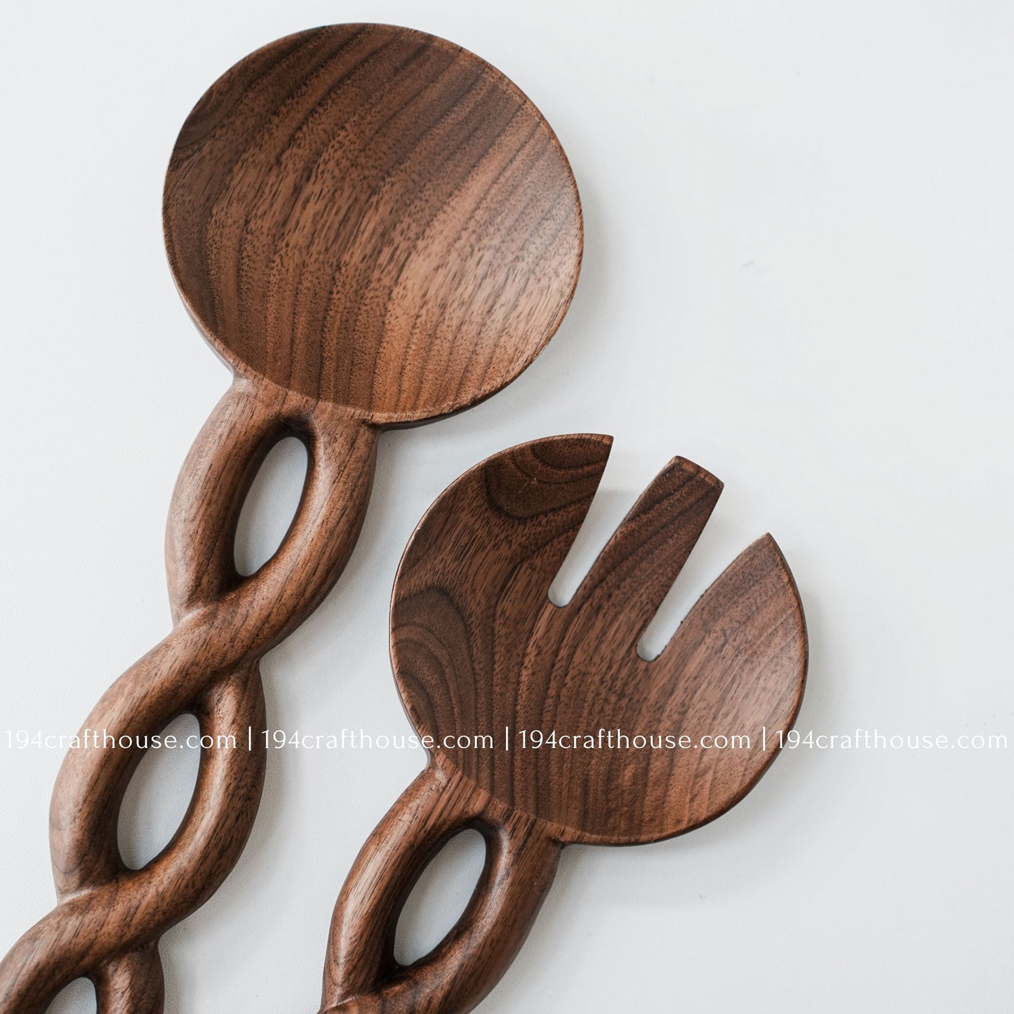 Handcrafted wooden salad servers showcasing smooth curves, chain-link handles, and natural wood grain