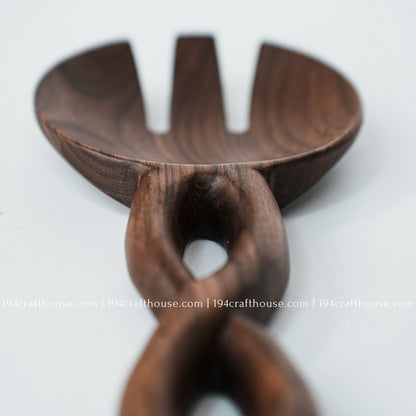 Close-up of the wooden salad spoon with a sculpted chain-link handle and smooth handcrafted finish