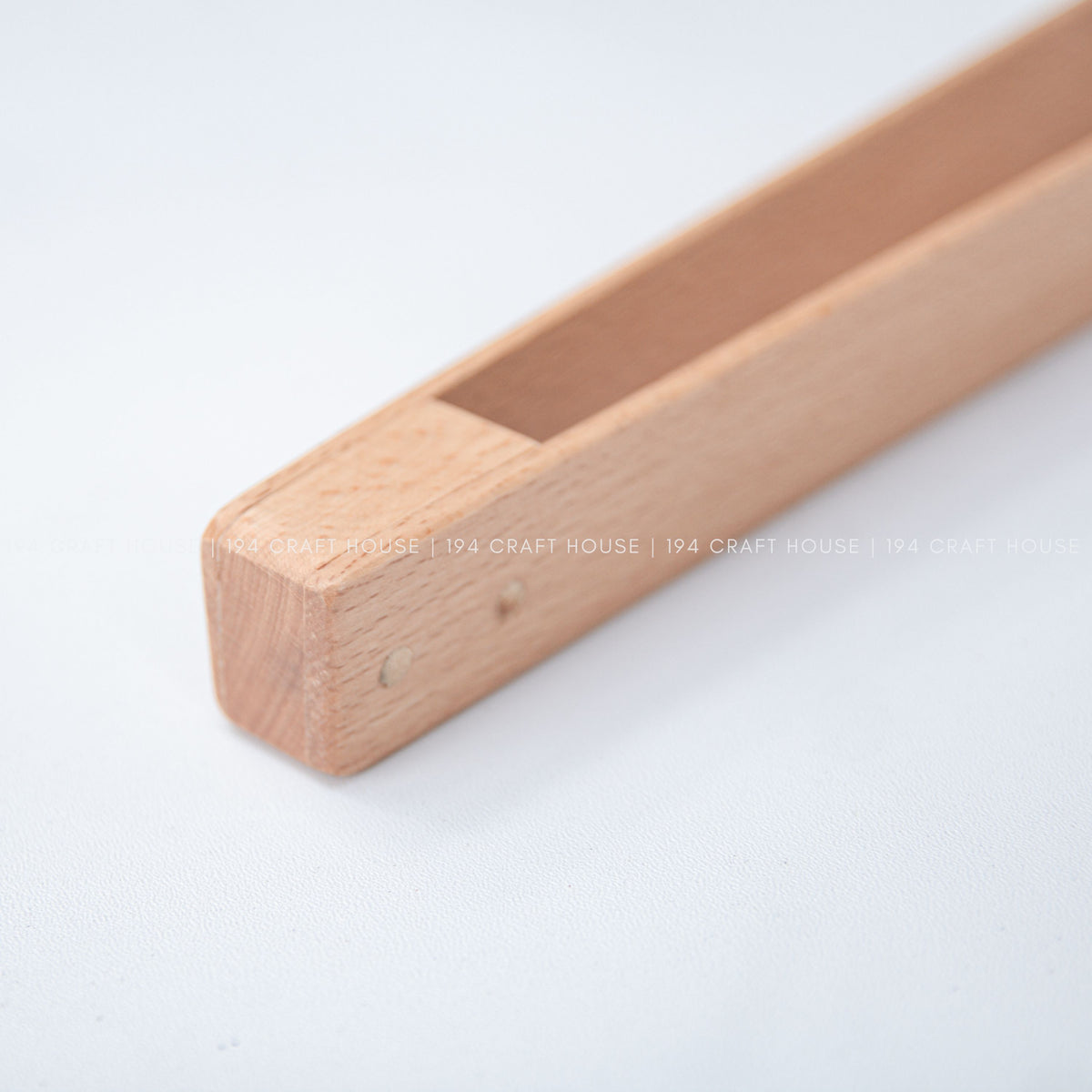 Close-up of the joined ends and rectangular opening of the wooden salad tongs.