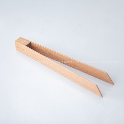 Beech wood salad tongs angled diagonally with their two arms open.