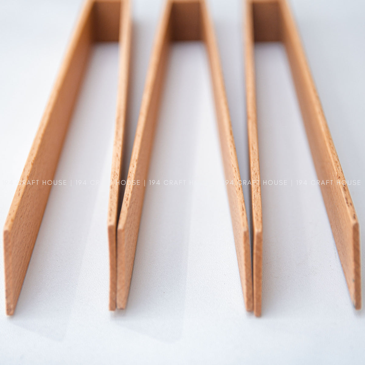 Close-up view of the narrow wooden ends and grain on the salad tongs.