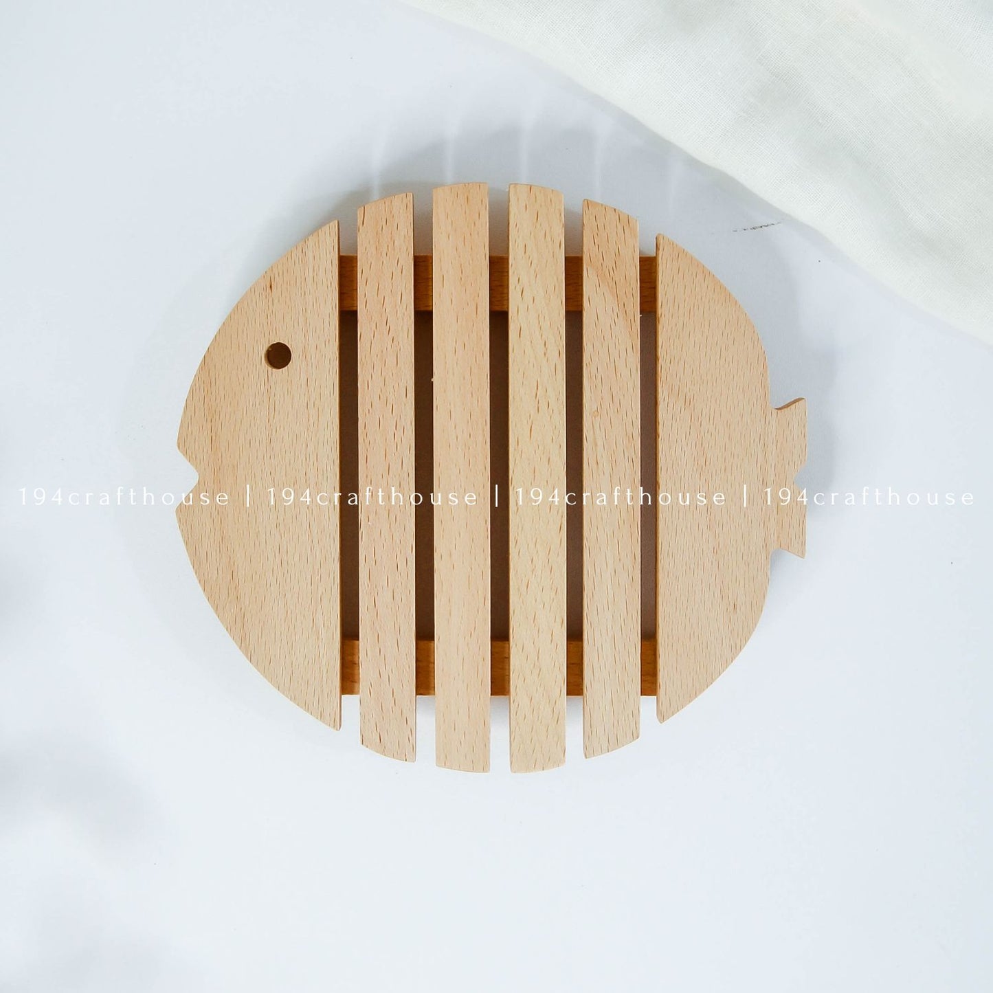 Top view of a fish-shaped wooden trivet designed for hot pots, pans, and serving dishes