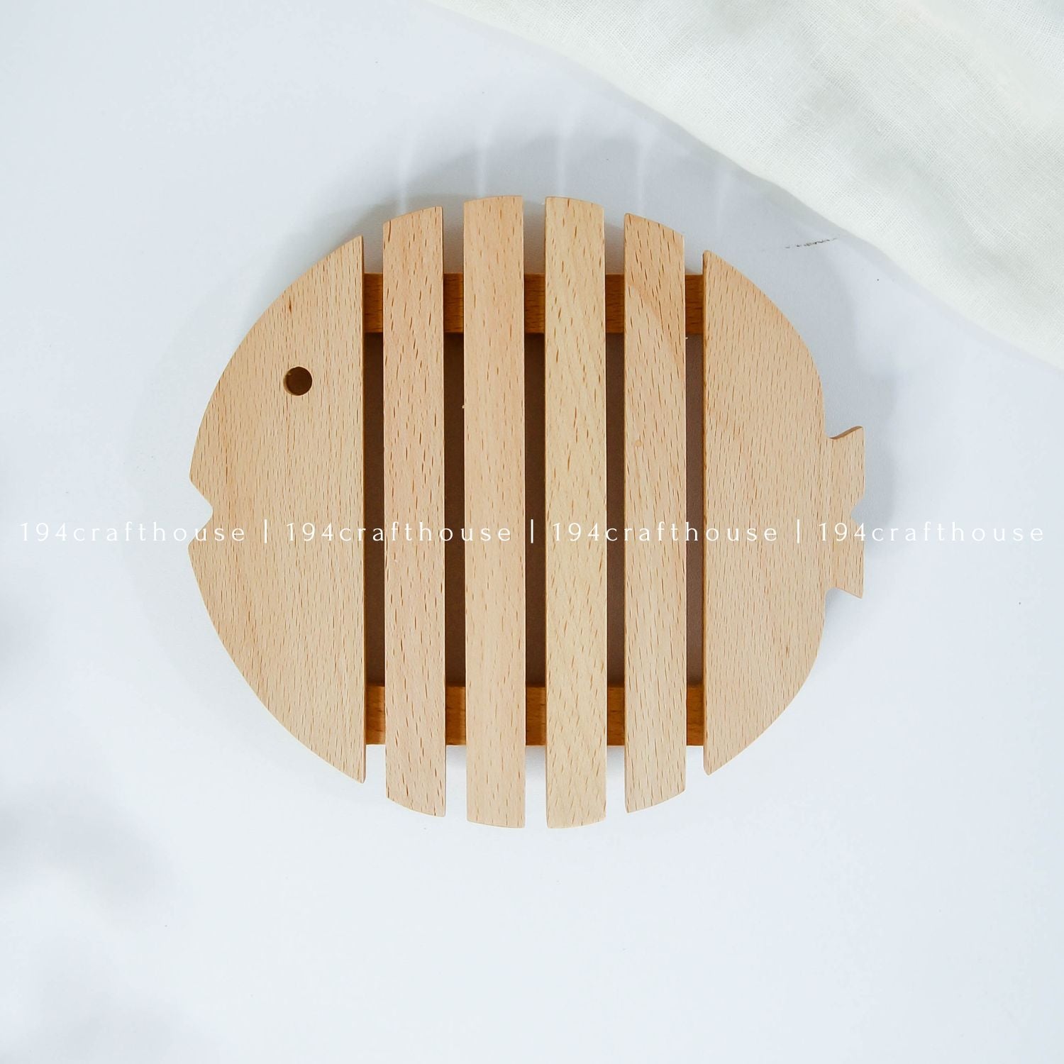 Top view of a fish-shaped wooden trivet designed for hot pots, pans, and serving dishes