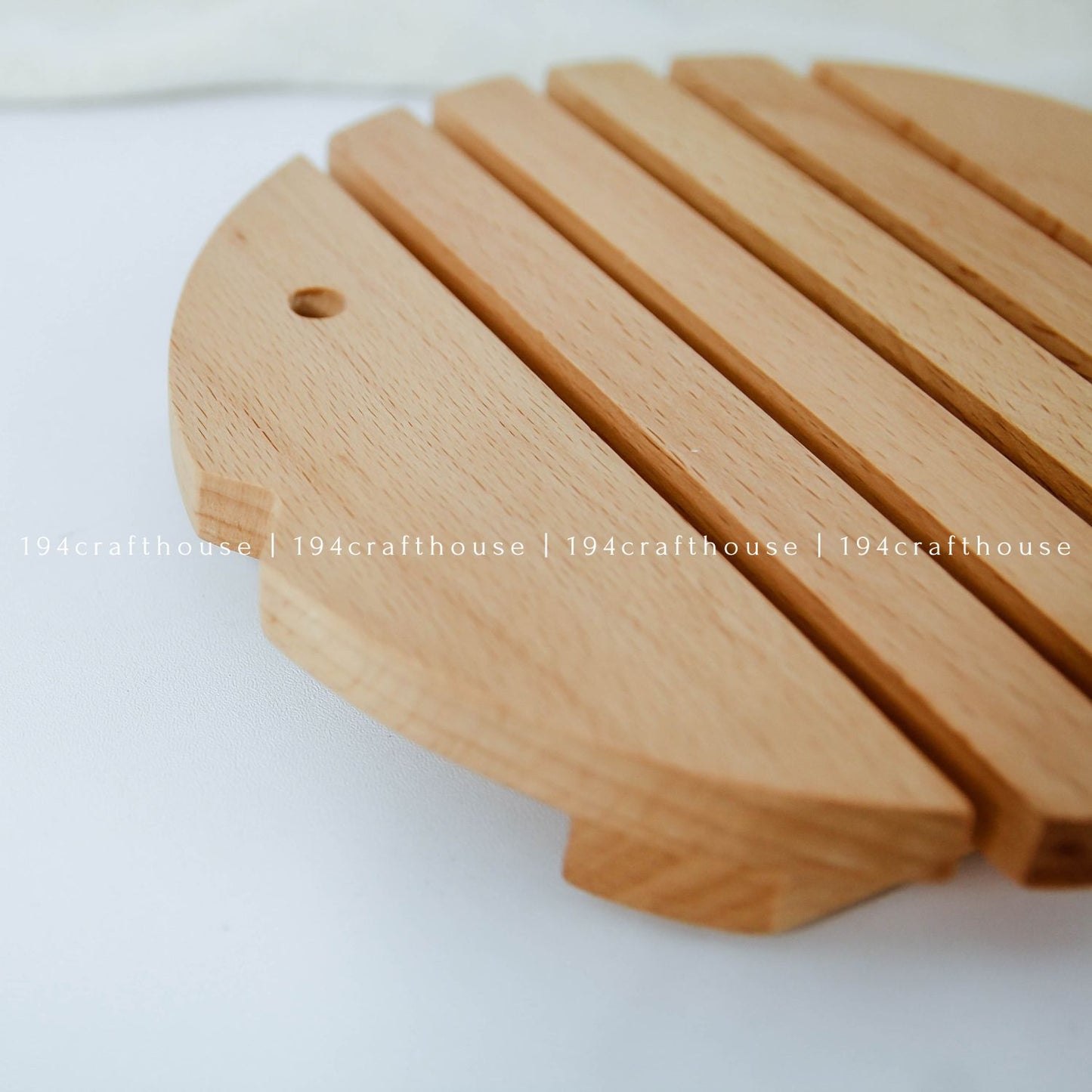 Close-up of a handcrafted wooden fish trivet showing its smooth finish and natural wood grain