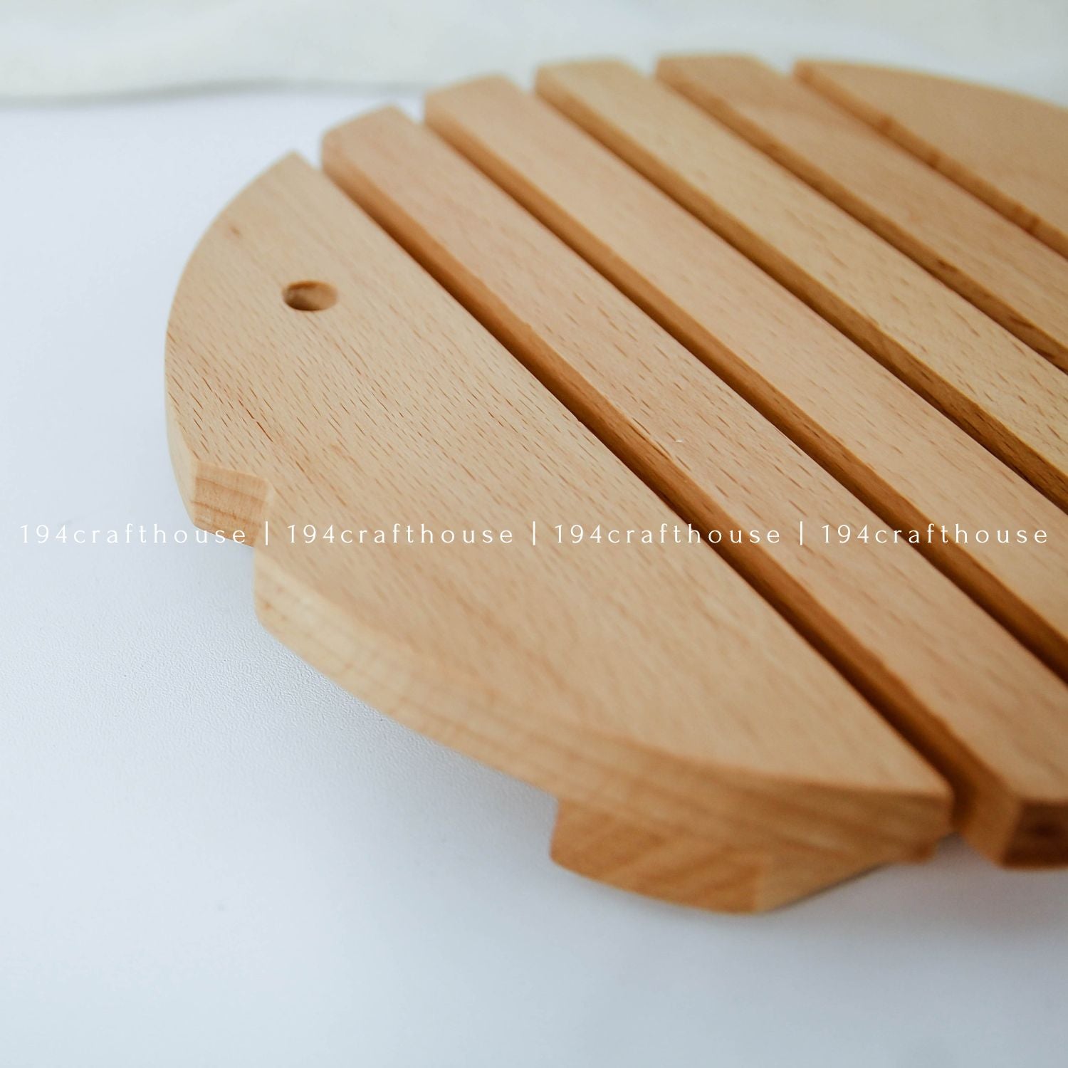 Close-up of a handcrafted wooden fish trivet showing its smooth finish and natural wood grain