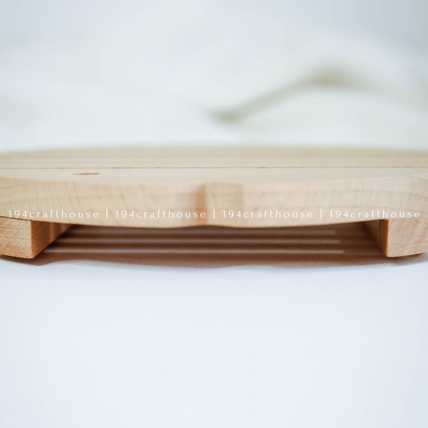 Handcrafted wooden fish trivet used as a heat-resistant pot holder on a kitchen surface