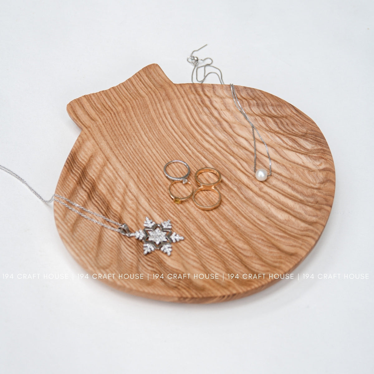 Top view of the shell-shaped ash tray arranged with rings and necklaces.