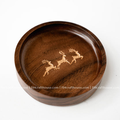 Close-up of a handmade walnut wood ring tray with engraved deer trio design and smooth rounded edges