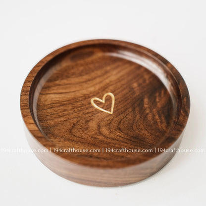 Handmade walnut wood ring tray featuring a small gold heart engraving and rich natural walnut grain