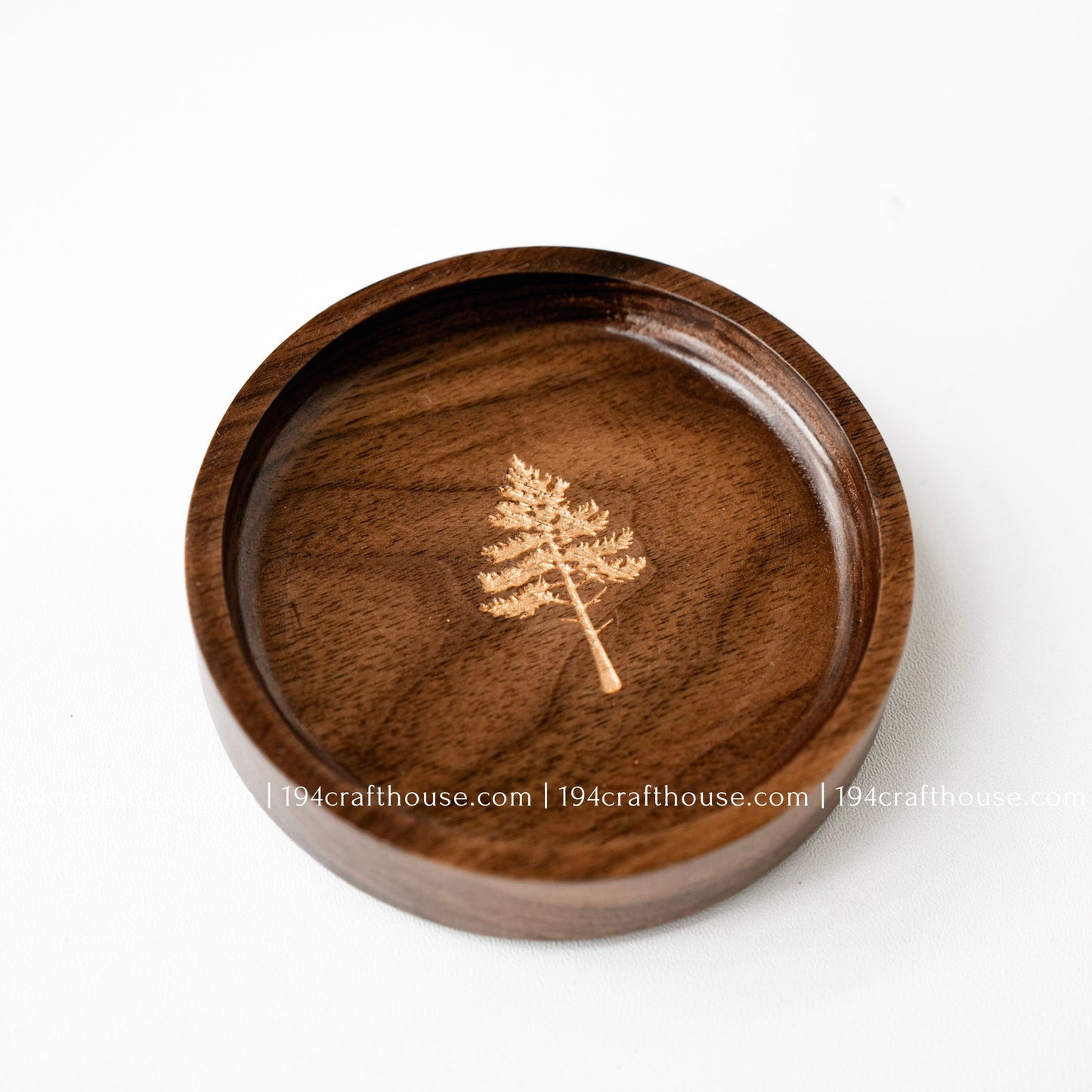 Handmade round walnut jewelry dish featuring a pine tree engraving and unique natural walnut wood grain