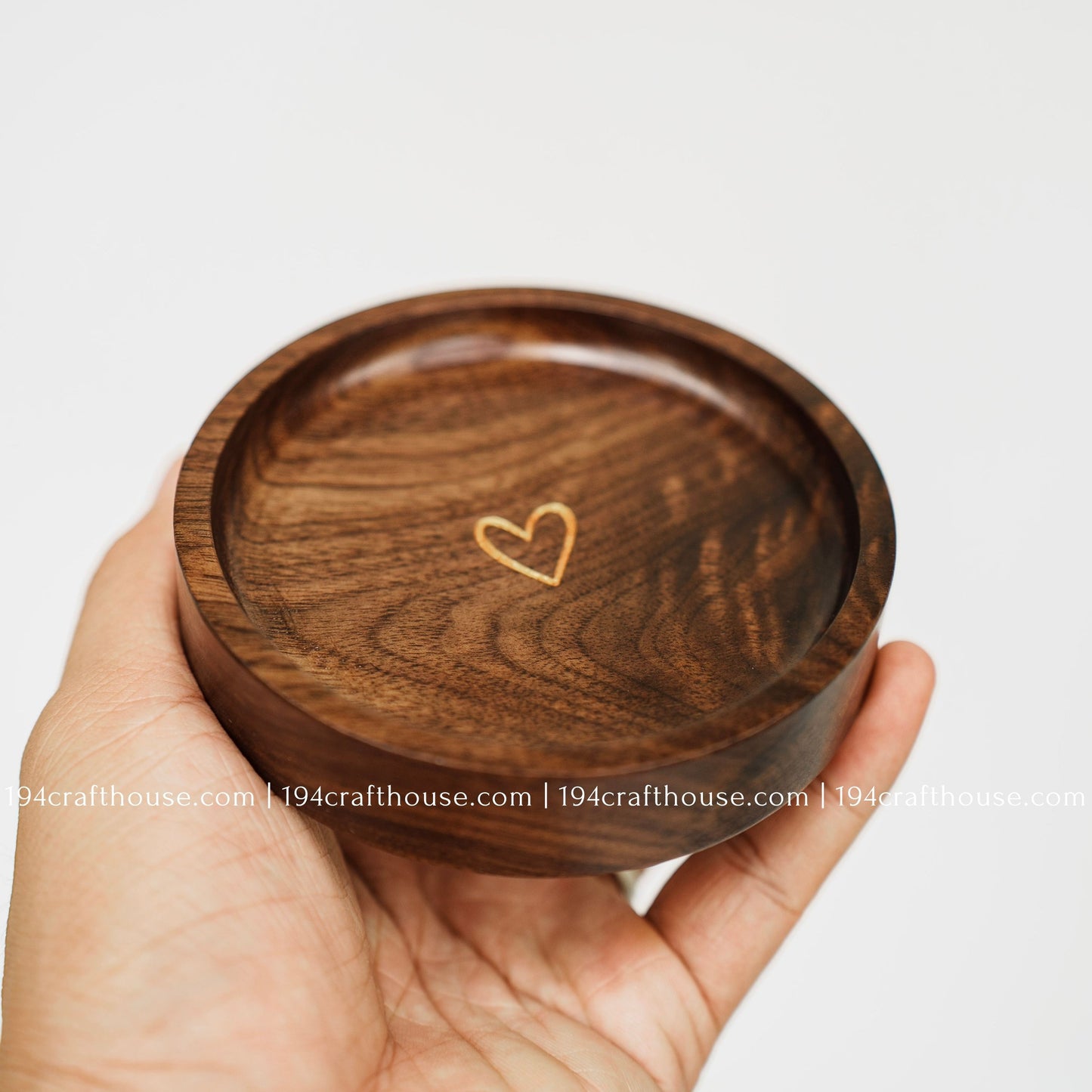 Handmade walnut wood jewelry dish with gold heart detail, shown in hand as a small ring and keepsake tray