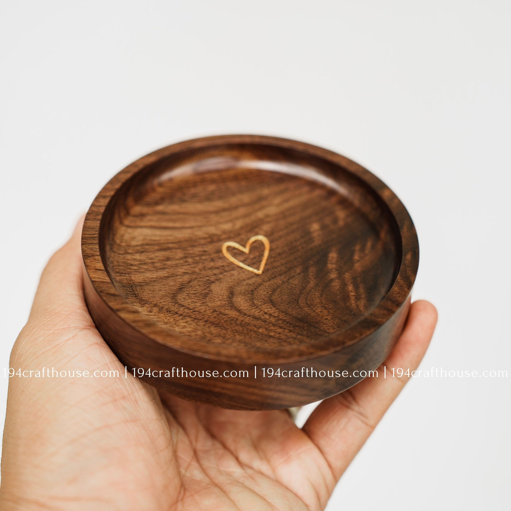 Handmade walnut wood jewelry dish with gold heart detail, shown in hand as a small ring and keepsake tray