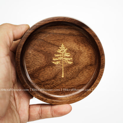 Handcrafted walnut wood jewelry tray with pine tree engraving held in hand, ideal for rings and small keepsakes