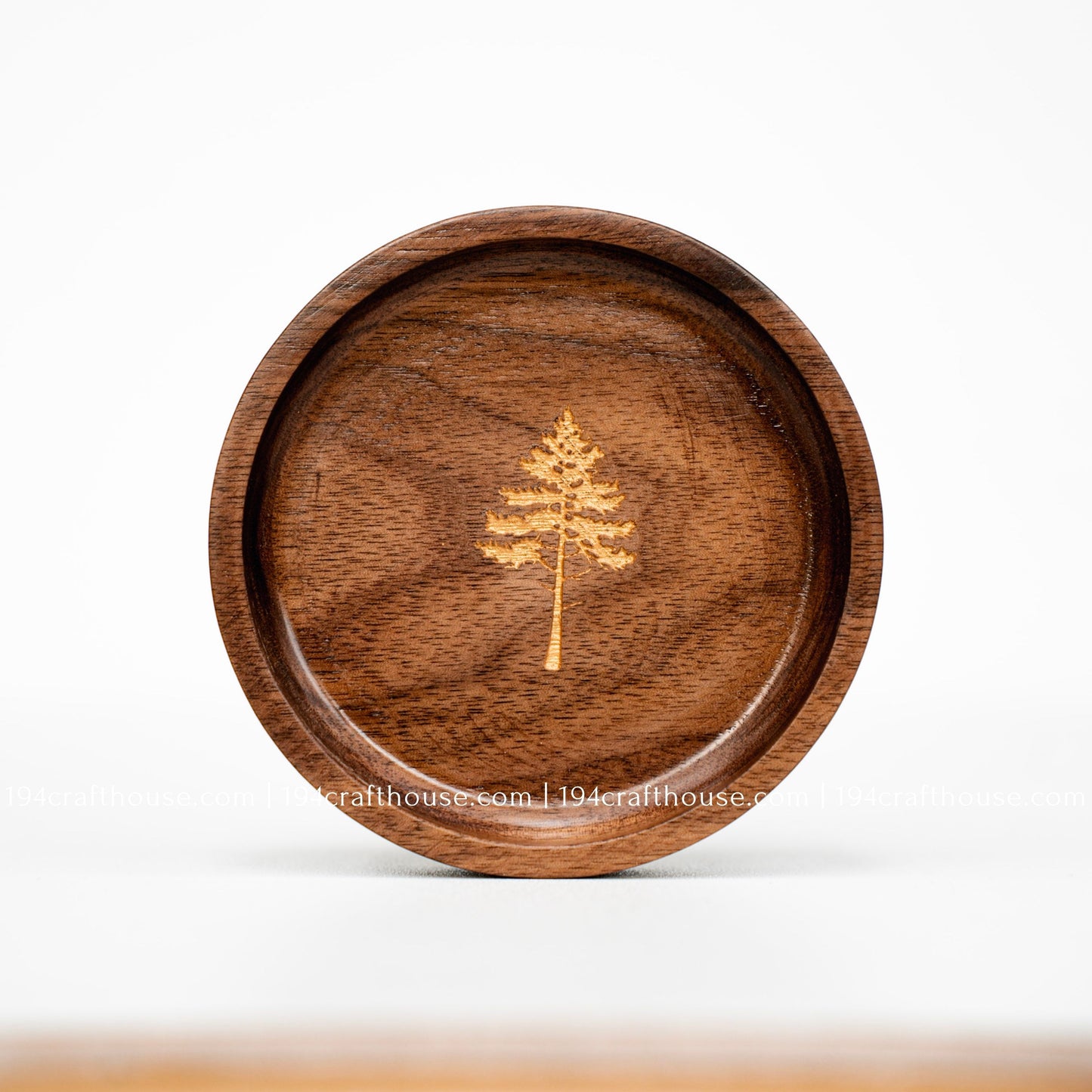 Round walnut wood ring dish with engraved pine tree design, smooth handcrafted finish, and rich natural wood grain