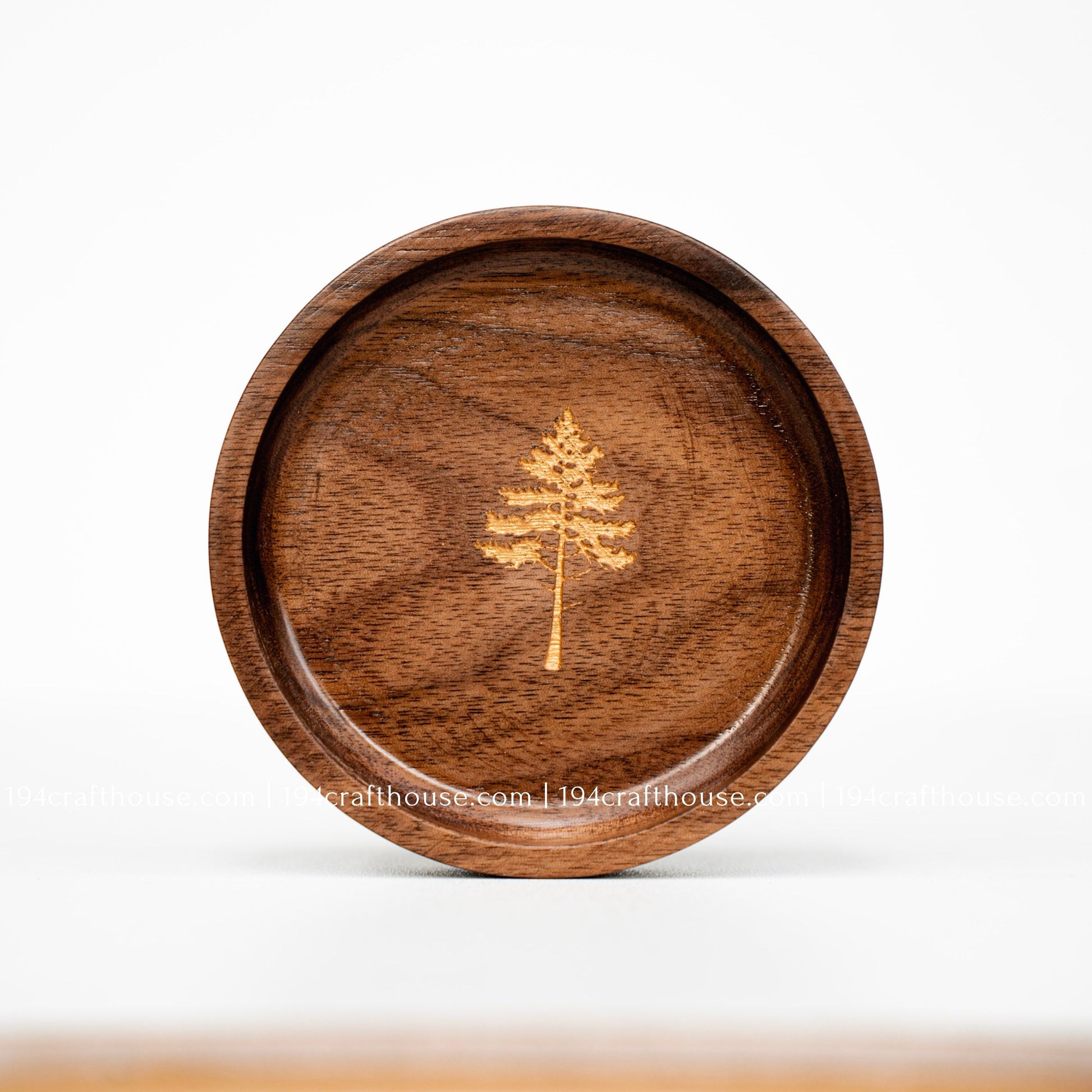 Round walnut wood ring dish with engraved pine tree design, smooth handcrafted finish, and rich natural wood grain