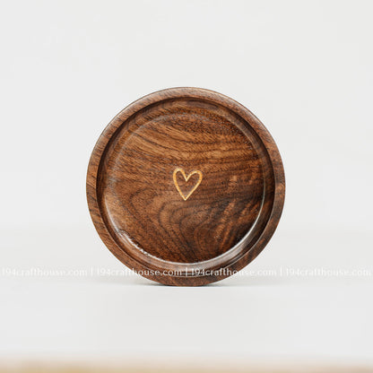 Top view of a round walnut wood ring dish with a delicate gold heart engraving and smooth handcrafted finish