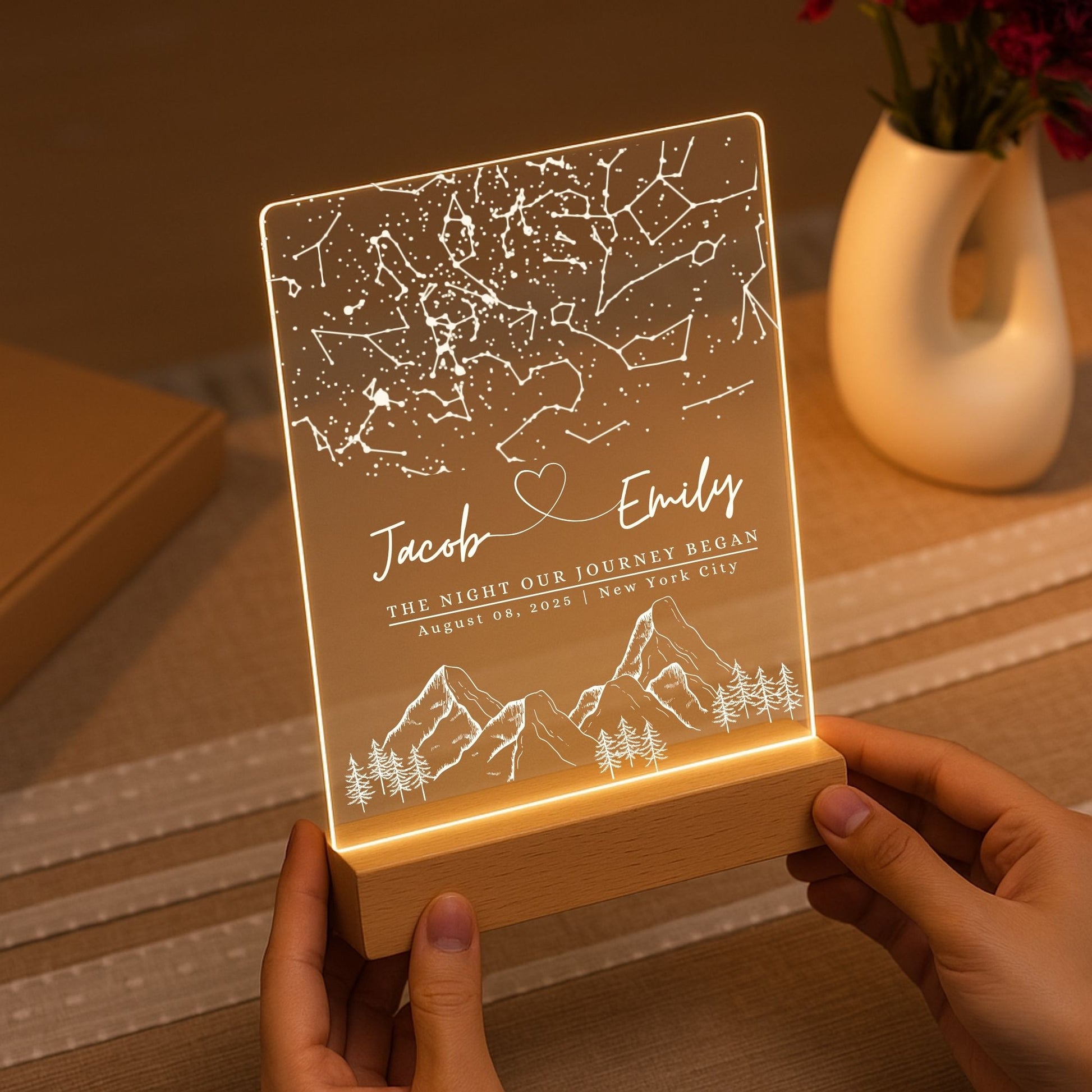 Handheld view of a transparent acrylic heart-shaped night light with a custom constellation design.