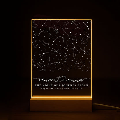 Close-up of the light reflection on a custom star map plaque against a dark, moody background.