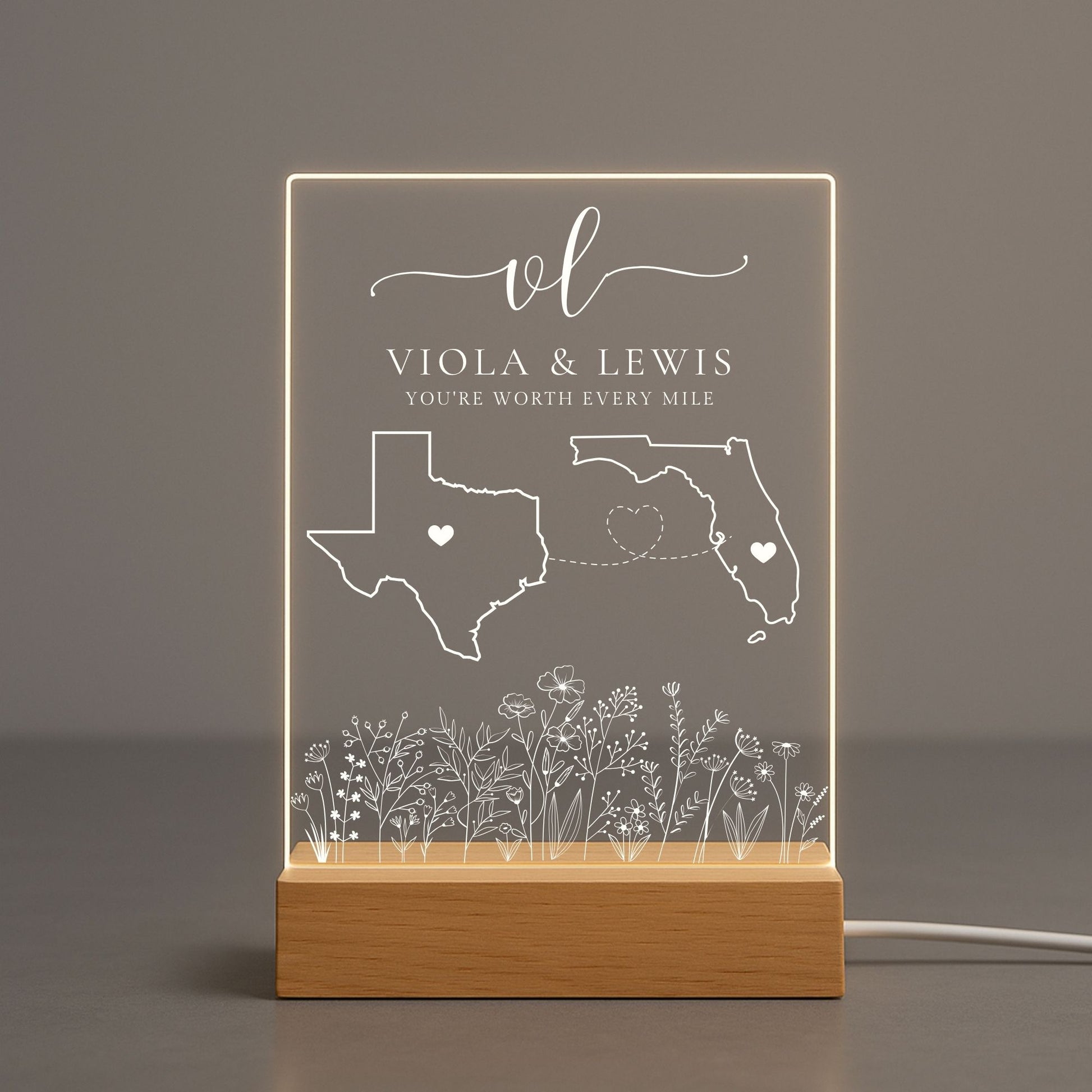 Transparent acrylic night light showing a couple names engraving between two states.