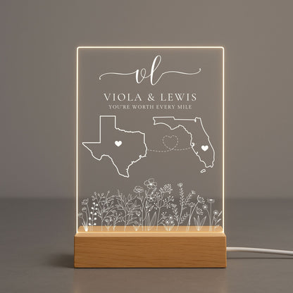 Transparent acrylic night light showing a couple names engraving between two states.