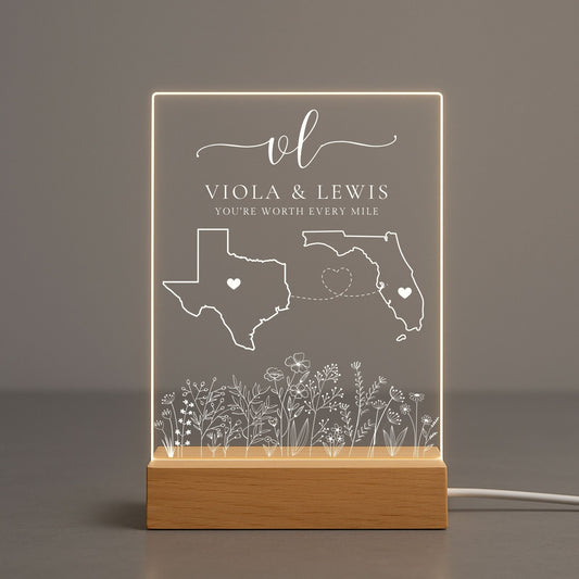 Transparent acrylic night light showing a couple names engraving between two states.