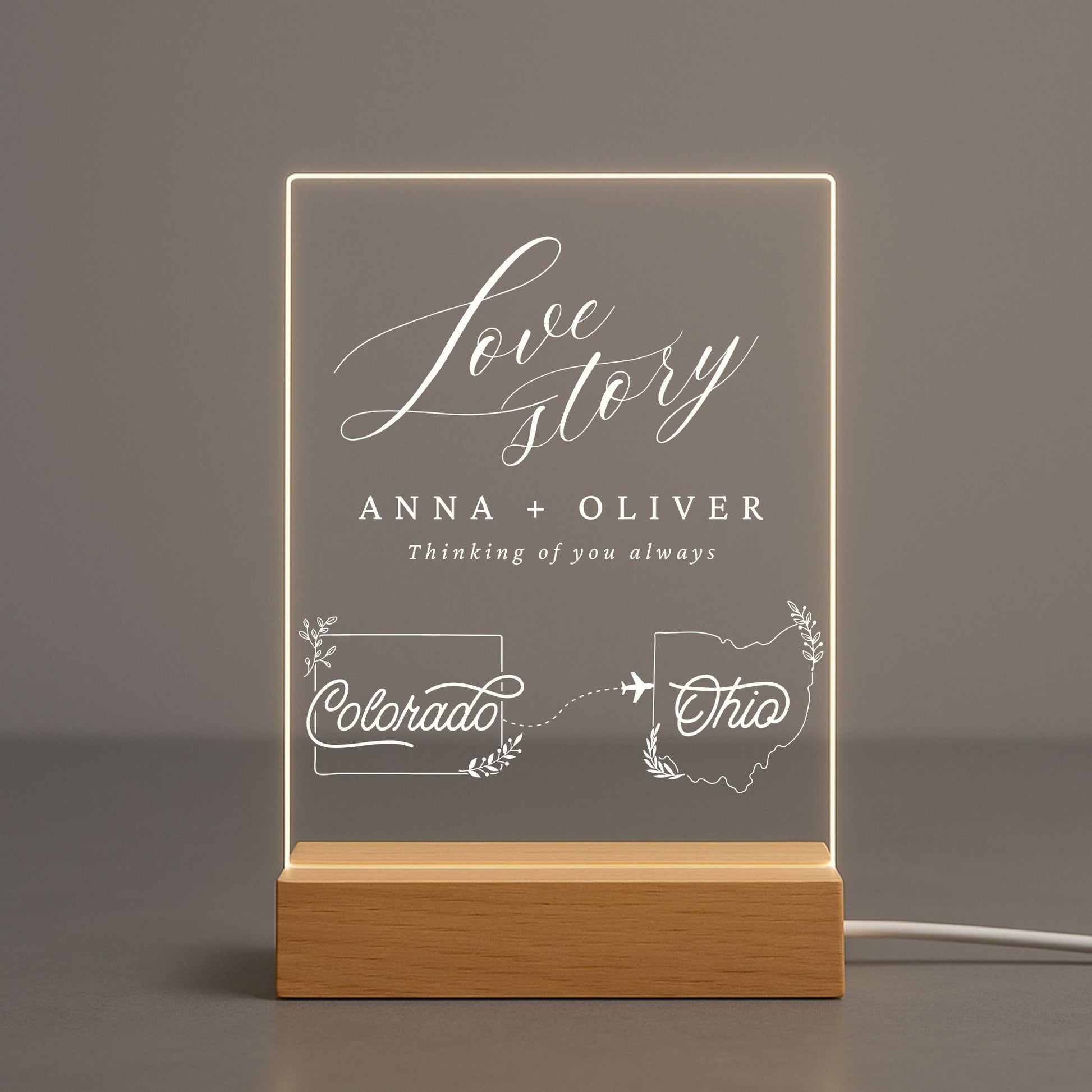 Acrylic light displaying two personalized state shapes and a couple's names.