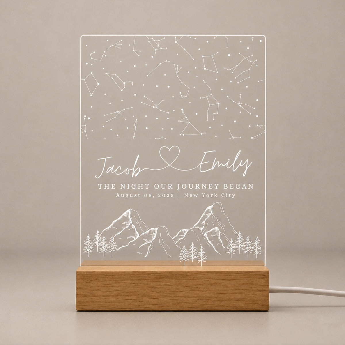 Front view studio shot of unlit laser-engraved acrylic star map night light seated securely in a solid beech wood base.