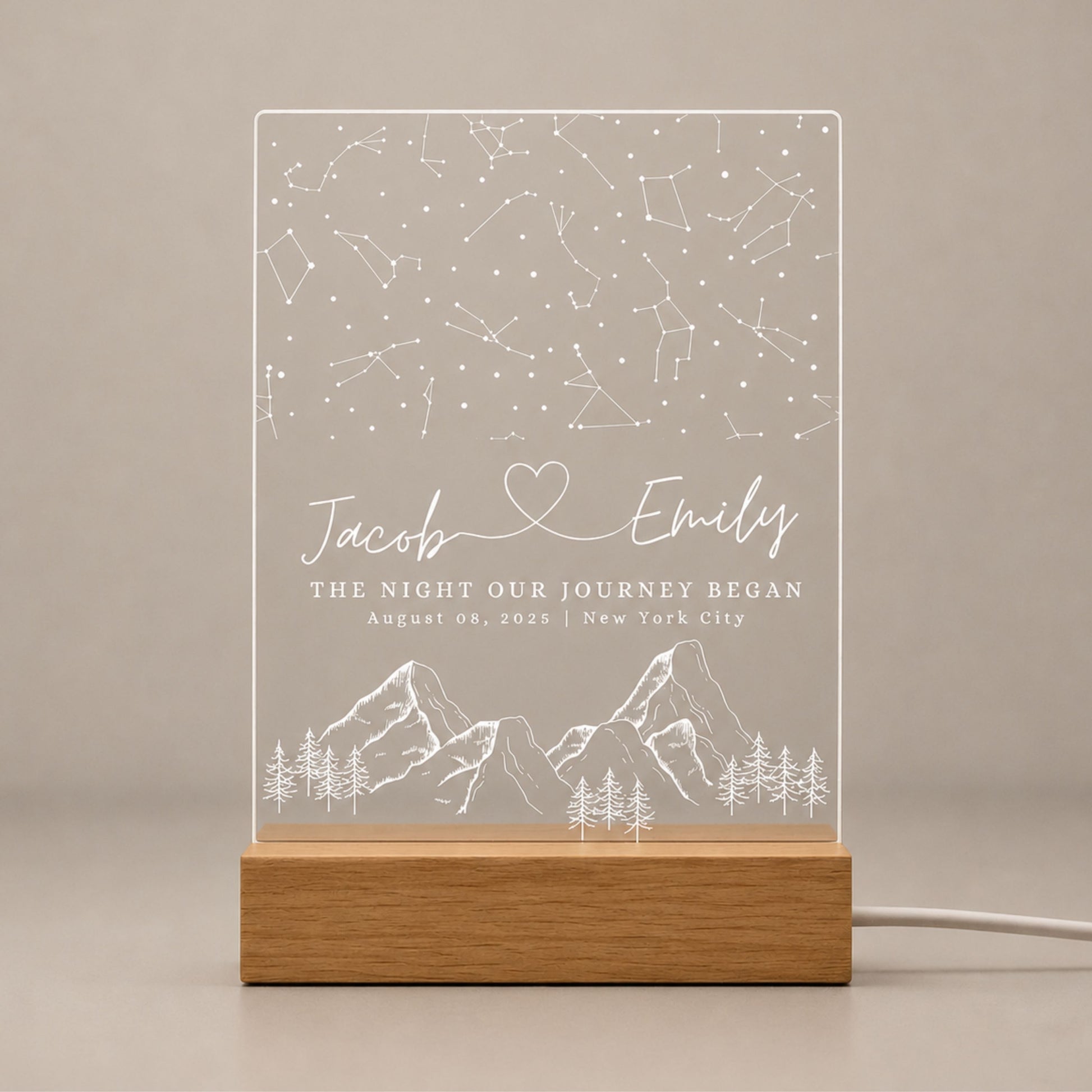 Front view studio shot of unlit laser-engraved acrylic star map night light seated securely in a solid beech wood base.