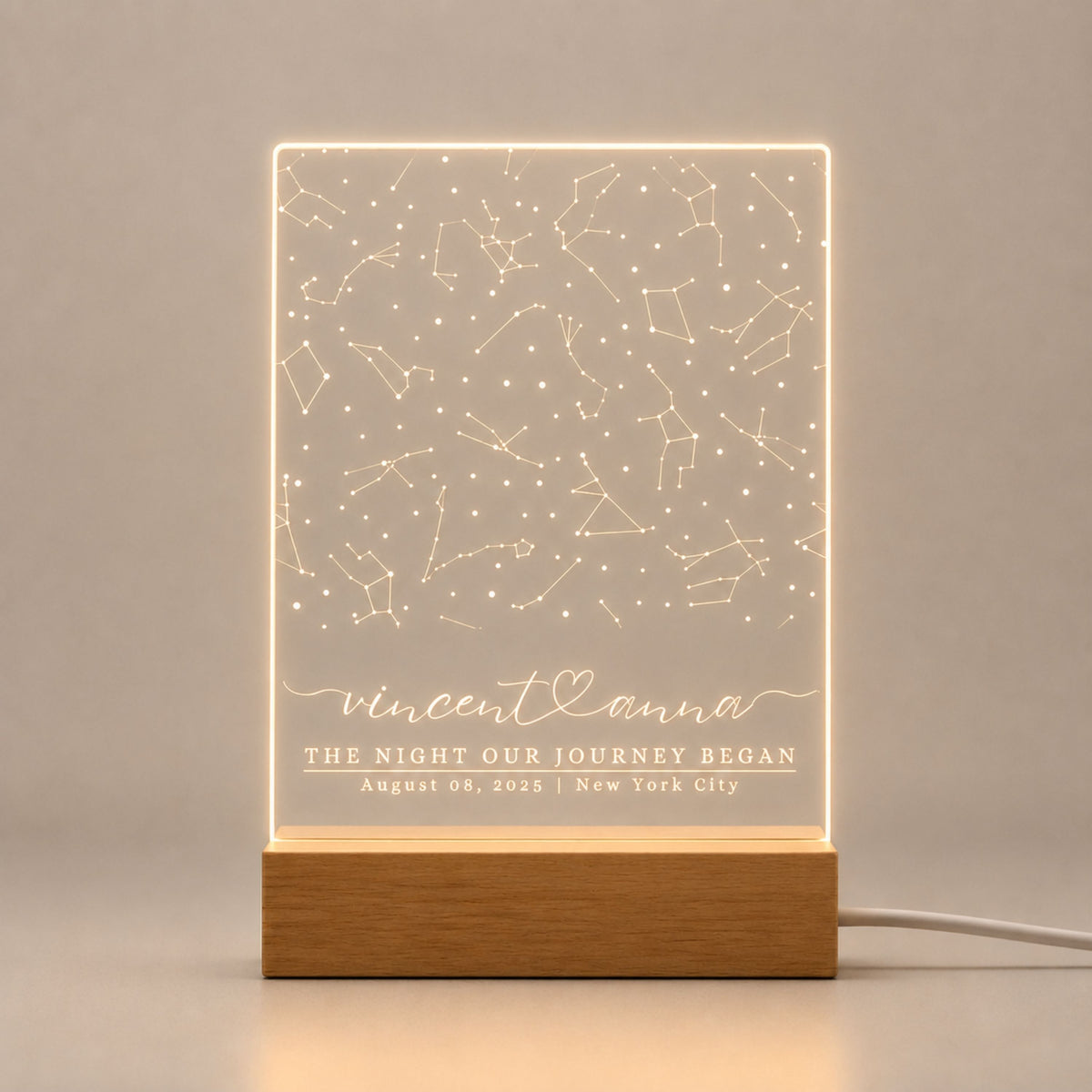 Studio front view of illuminated full-surface star map acrylic lamp glowing warm white on a natural wooden LED stand.