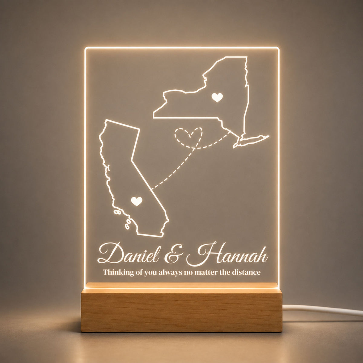 Studio front view of illuminated two-state long distance map acrylic lamp glowing warm white on a natural wooden LED stand.