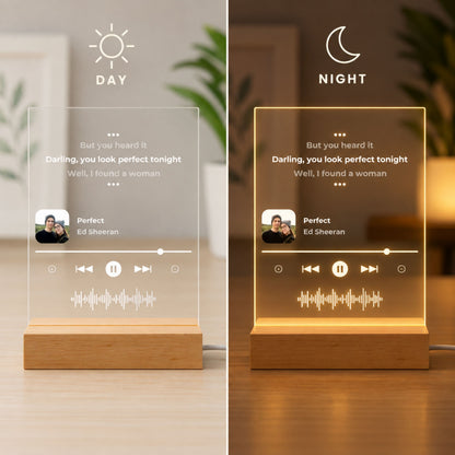 Day and night split display of song lyrics music player acrylic lamp showing unlit white lettering in daylight and warm LED glow at night.