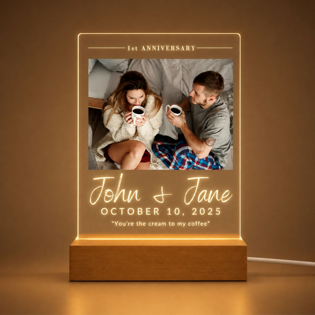 Front view of custom couple anniversary acrylic plaque illuminated with warm LED backlight mounted on a natural wood base.